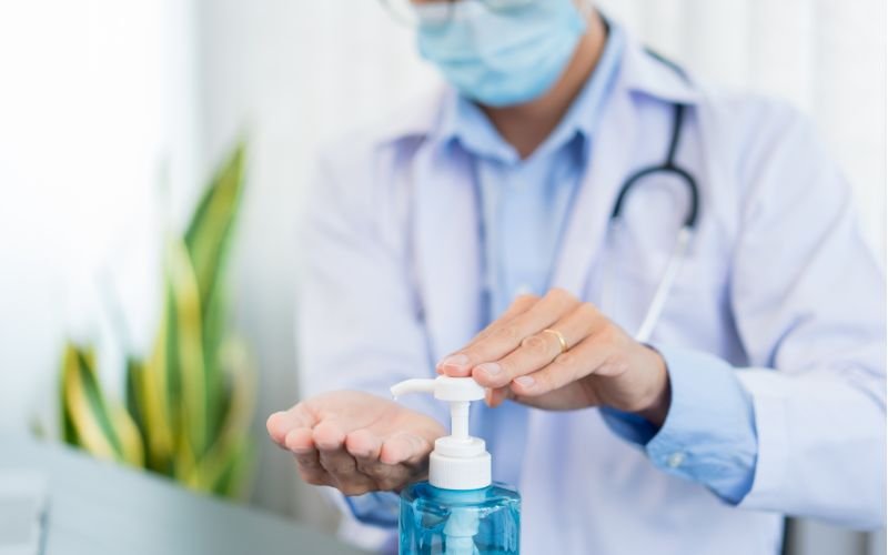 Visitor using hand sanitizer dispenser at hospital entrance in Nigeria and Kenya