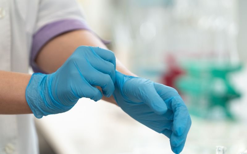 Nurse wearing nitrile surgical gloves in Nigeria and Kenya hospital ward